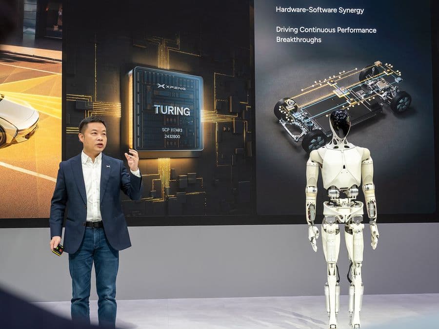 XPeng chairman He Xiaopeng on stage beside the IRON humanoid robot